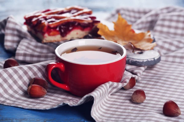 Tasse Tee mit Herbstdekor auf Holztisch. — Stockfoto