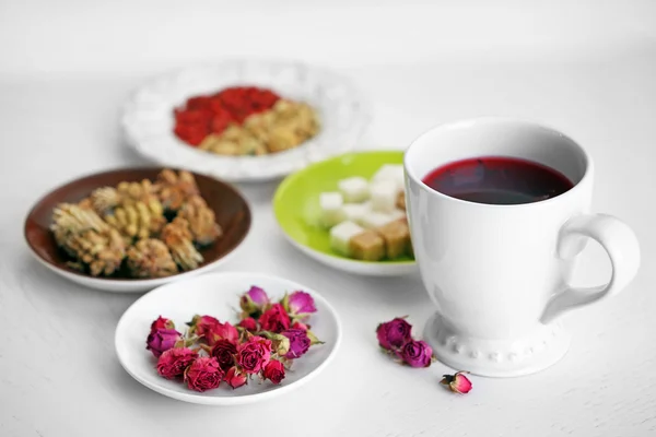 Kopje thee met aromatische droge thee op houten achtergrond — Stockfoto