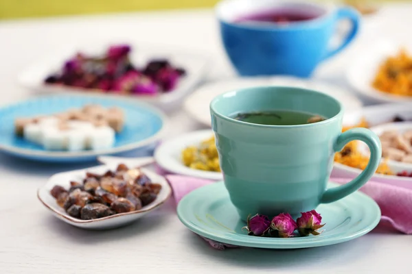 Taza de té con té seco aromático sobre fondo de madera — Foto de Stock