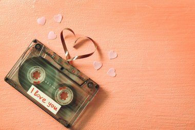 Pembe dokulu arka plan üzerinde kalp şeklinde kasetle Retro ses kaseti