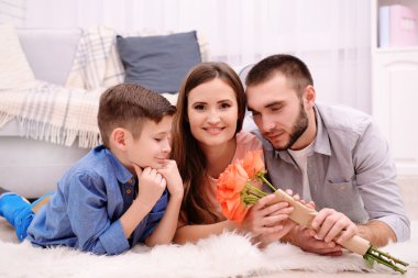 Mutlu aile halı odasında kanepe yanında yatan