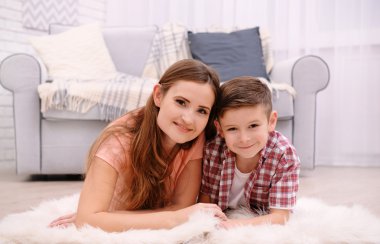 Anne ve oğlu halı odasında kanepe yanında yatan