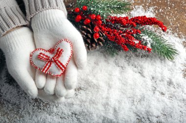Mittens kar arka plan üzerinde dekoratif kalpli kadın elinde