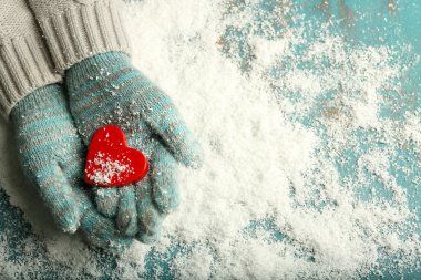Mittens kar arka plan üzerinde dekoratif kalpli kadın elinde