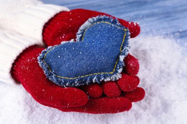 Mittens kar arka plan üzerinde dekoratif kalpli kadın elinde