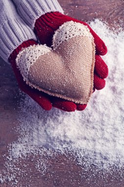 Mittens kar arka plan üzerinde dekoratif kalpli kadın elinde