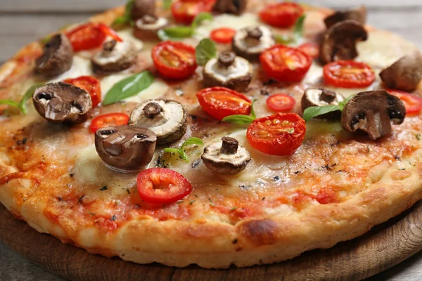 Lekkere verse pizza versierd met champignons en tomaten — Stockfoto