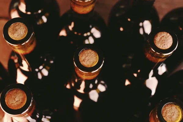 Montones de botellas de vino sobre fondo de madera, vista al revés. De cerca. — Foto de Stock