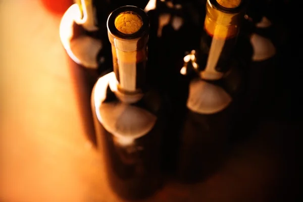 Stacks of wine bottles on wooden background, upside view. Close up — Stock Photo, Image