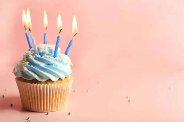 Tasty cupcake decorated with candle on pink background — Stock Photo, Image