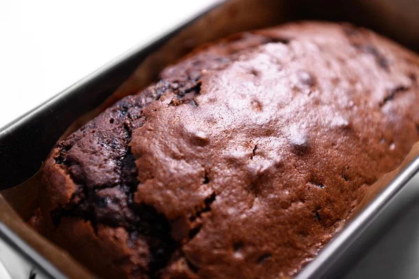 Pastel de chocolate en bandeja para hornear sobre mesa blanca — Foto de Stock