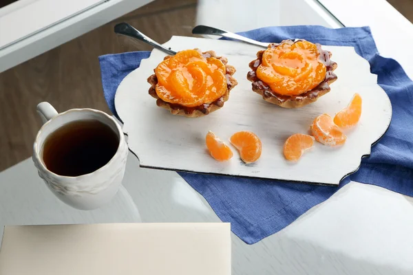 Pasteles dulces con mandarinas en la mesa, de cerca — Foto de Stock