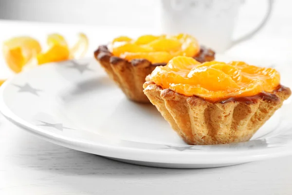 Zoet gebak met mandarijnen op tafel, close-up — Stockfoto