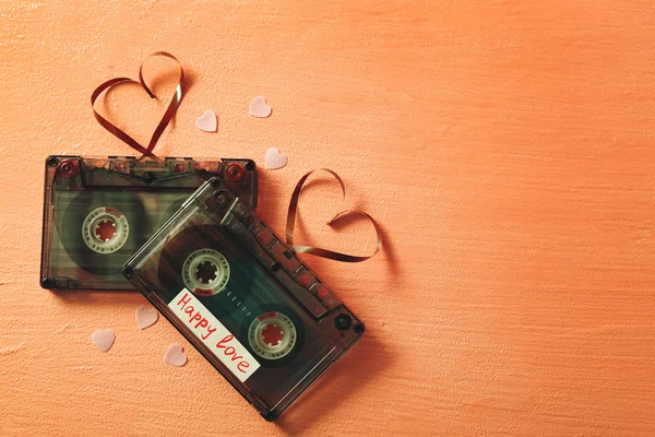 Ретро аудіокасети зі стрічками у формі сердець на рожевому текстурованому фоні — стокове фото