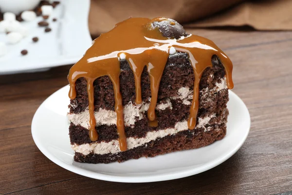 Ahşap masa portre karamel ile çikolatalı kek parçası — Stok fotoğraf