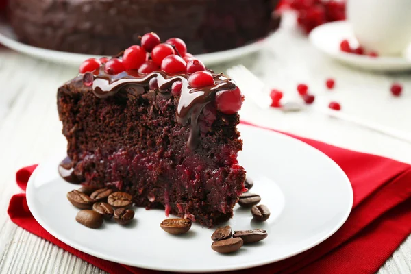 Bit av chokladkaka med tranbär på plattan, närbild — Stockfoto