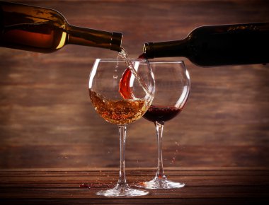 Beyaz ve kırmızı ahşap arka plan üzerinde bardaklarda dökme şarap