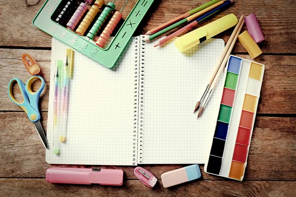 Caderno e artigos de papelaria da escola brilhante na mesa de madeira velha — Fotografia de Stock