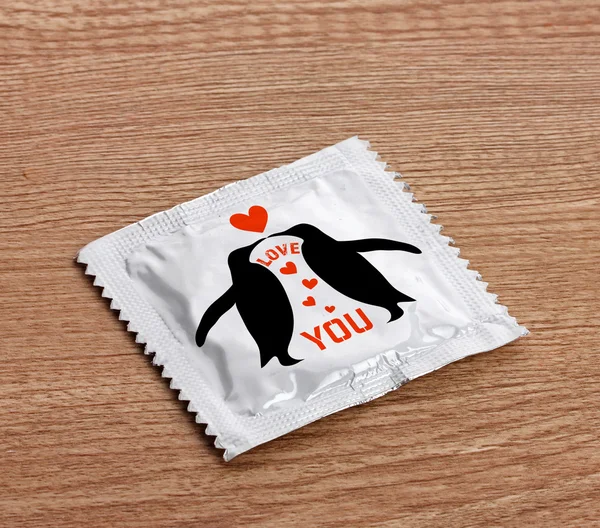 Condom on wooden table — Stock Photo, Image