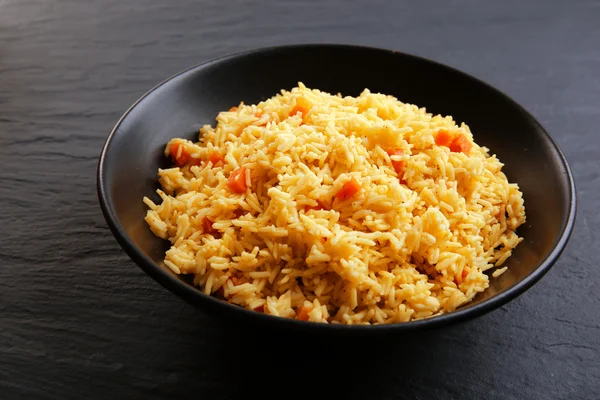 Тушеный рис с морковью на тарелке — стоковое фото