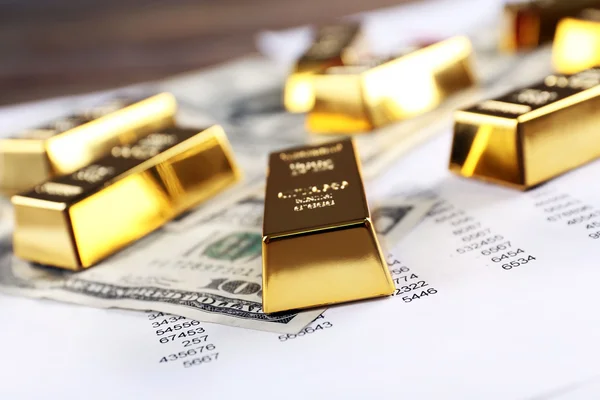 Золоті батончики з доларовими банкнотами — стокове фото