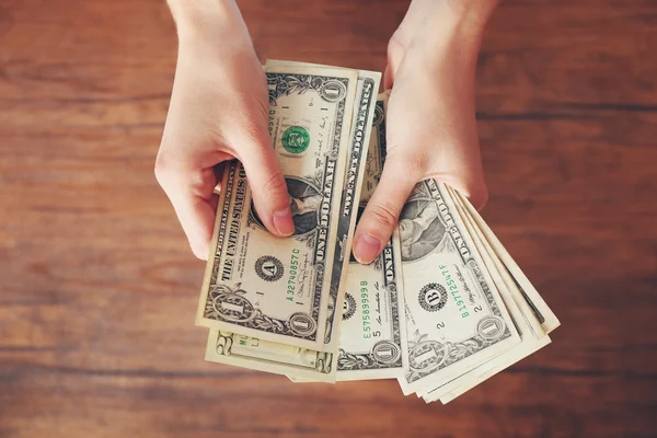 Mãos a segurar notas de dinheiro — Fotografia de Stock