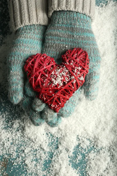 Hände in Fäustlingen mit dekorativem Herzen — Stockfoto
