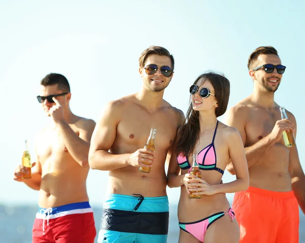 Amigos felices bebiendo cerveza en la playa — Foto de Stock