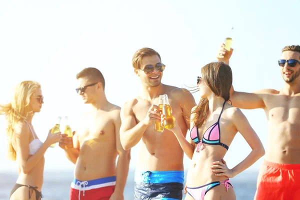 Amigos felices bebiendo cerveza en la playa —  Fotos de Stock