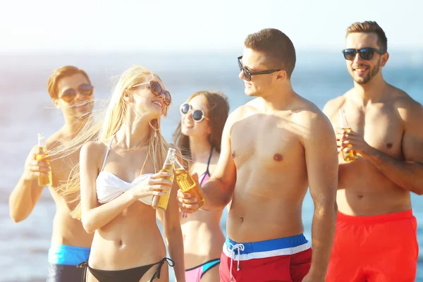 Happy vrienden drinken bier op strand — Stockfoto