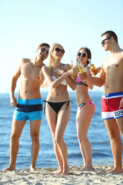 Happy vrienden drinken bier op strand — Stockfoto