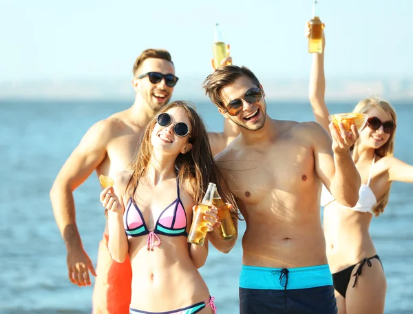 Happy friends drinking beer at beach — Stock Photo, Image