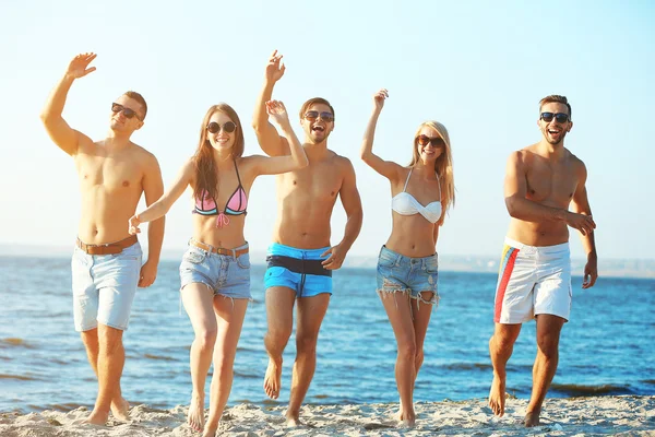 Amici felici che corrono in spiaggia — Foto Stock