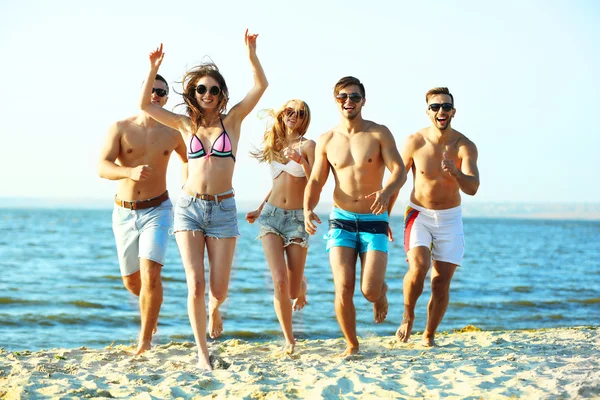Amici felici che corrono in spiaggia — Foto Stock