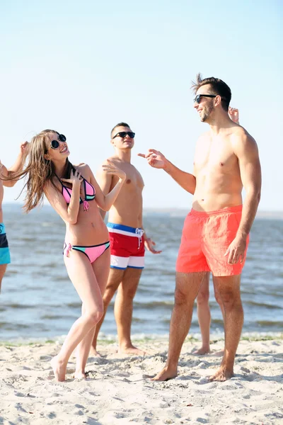 Happy couple and friends relaxing at beach — Stock Photo, Image