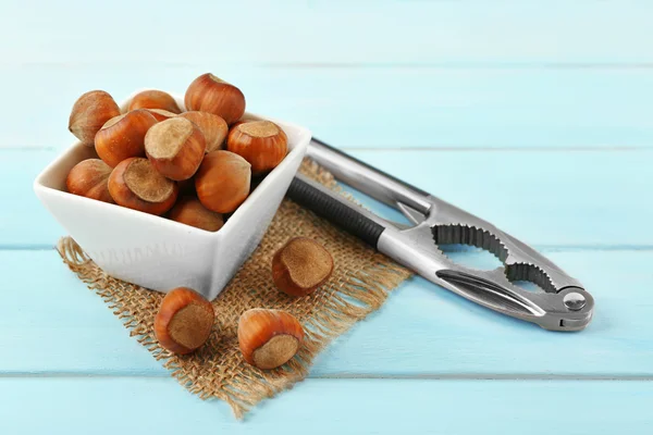 Hazelnuts in the bowl and nutcracker — Stock Photo, Image