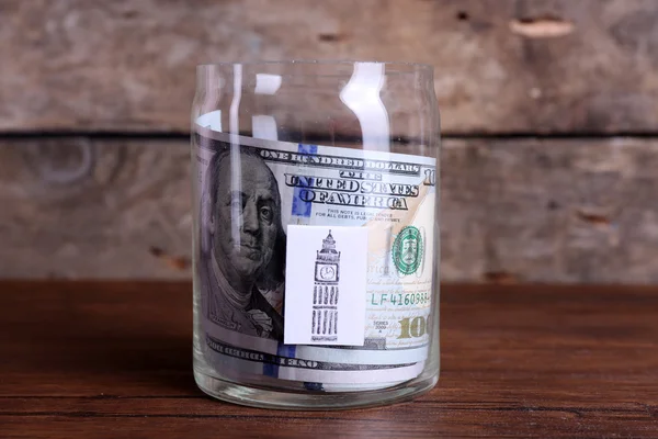 Rollo de billetes de dólar en un frasco de vidrio — Foto de Stock