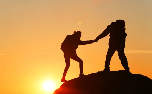 Man en vrouw beklimming van de berg — Stockfoto