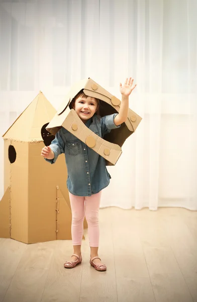 Menina brincando com foguete espacial de papelão — Fotografia de Stock