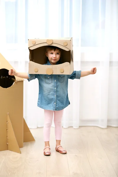 Girl playing with cardboard space rocket — Stock Photo, Image