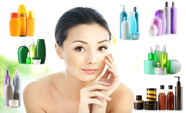 Mujer con maquillaje suave y botellas de cosméticos —  Fotos de Stock