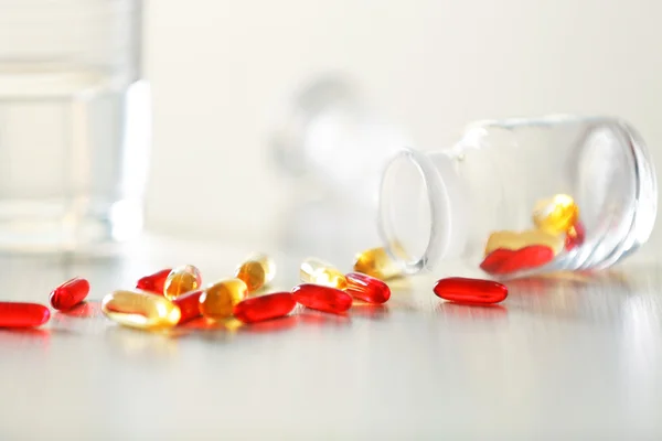Cápsulas coloridas derramadas del frasco de pastillas —  Fotos de Stock