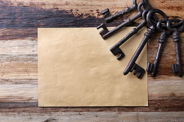 Bunch of old keys with empty sheet of paper — Stock Photo, Image