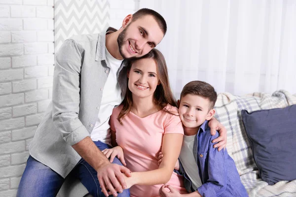 Família sentada no sofá em casa — Fotografia de Stock