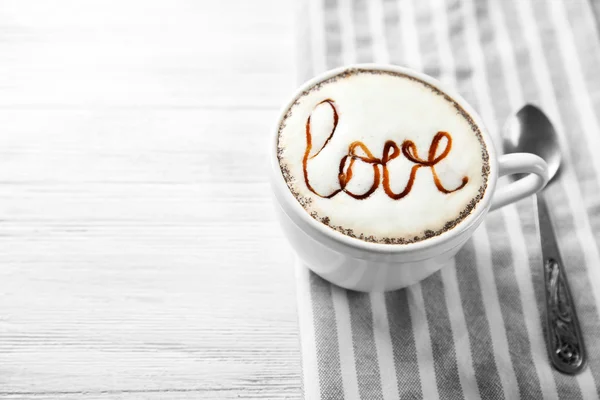 Cup of cappuccino with chocolate syrup — Stock Photo, Image