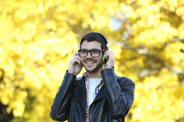 Man, luisteren naar muziek in een park — Stockfoto