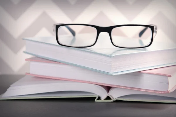 Books and eyeglasses on grey table — Stock Photo, Image