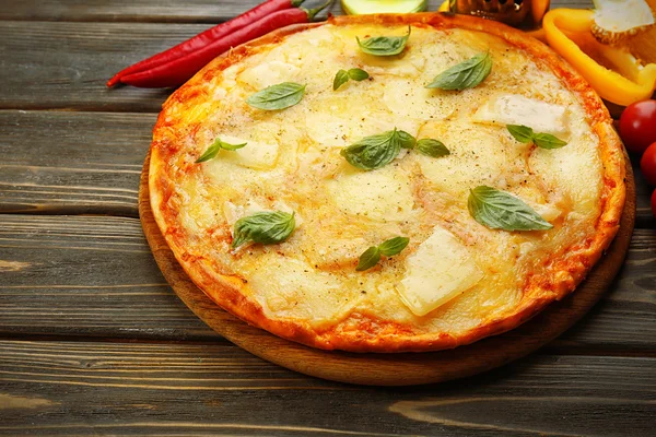 Tasty pizza decorated with basil and vegetables — Stock Photo, Image