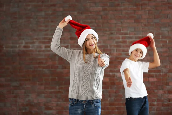 Primos felizes se divertir em santa chapéu — Fotografia de Stock