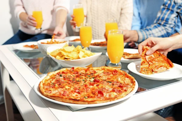 Amigos mãos segurando pizza quente — Fotografia de Stock